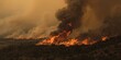 © AkuAku - Wildfire Burning Through Forested Landscape Under Smoky Skies