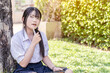 © Atiwat - Closeup Thai high school girls in uniform using a tablet outdoors, Asian teen girl cute pretty cheerful happy smiling, Thinking idea.