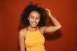 © Gonzalo Infiesta - Smiling young african american woman touching curly hair