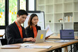 © saltdium - Asian Business Colleagues Reviewing Financial Charts and Data on Laptop in Modern Office