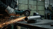 © Creative Valley - Industrial worker grinding steel pipe with angle grinder, producing embers in a workshop, representing metal fabrication, machining, manufacturing, construction, engineering and workplace safety