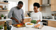 © tom - Happy African American Couple Cooking Healthy Meal Together in Modern Kitchen