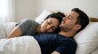 © Elenba - Young couple sleeping together in bed. Woman resting her head on man's chest. Intimacy and relationship concept