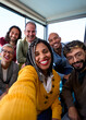 © CarlosBarquero - Vertical Selfie of a group of happy multiracial business people taking photo with a phone in the office