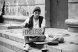 © Pixel-Shot - Homelessness and poverty, young man holding a homeless sign begging for help on urban street steps