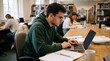 © Felippe Lopes - Young man focused on laptop in library surrounded by books and other students studying