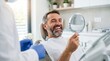 © Eduardo - Happy male patient looking at his new smile in a dental mirror