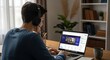 © Mohsin - Man attends an online video call using his laptop at home.