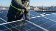 © Al - Technician installing solar panels on rooftop with screwdriver for green power energy