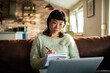 © Davor - Thoughtful woman taking notes while studying at home