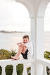 © Cavan Images - Happy boy sits barefoot on a seaside balcony