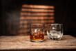 © aekachai - Whiskey Glass with Ice Cubes on Wooden Table in Bar