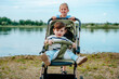 © Westend61 - A smiling girl pushes her baby brother in a stroller by the pond