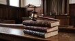 © Felippe Lopes - Gavel resting on a stack of antique law books in a courtroom setting