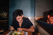© Angel Santana/Stocksy - Young man laughing while enjoying a meal out