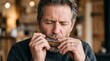 © NoblePix - Mature Man Playing Harmonica with Eyes Closed and Focused Expression