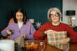 © Westend61 - Mother and daughter wrap a Christmas present indoors