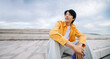 © Julia - Young man sitting outdoors looking thoughtful on steps