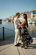 © Mauro Grigollo/Stocksy - A couple embracing by the town harbour during vacation