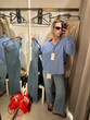 © Asya Molochkova/Stocksy - Woman Trying on Jeans in Store Fitting Room Mirror Selfie