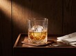 © Komandan - Glass of whiskey on wooden table with newspaper.
