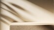 © Viktor - Minimalist beige podium for product presentation. Natural sunlight shadows fall on stone platform with organic texture. Empty concrete stage background offers clean space for cosmetic mockup luxury