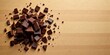 © Prakaikan - A delectable pile of broken dark chocolate pieces scattered on a light wood surface, offering a tempting visual of sweet indulgence and rich flavor
