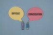 © Ilyas - Difficult Conversation Concept With Tiny Couple Figures And Speech Bubbles Representing Communication And Conflict, isolated on blue background.