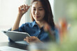 © tippapatt - Asian business woman architect using digital tablet for creating interior design project in modern studio office.