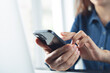 © tippapatt - Close up, business woman using smartphone with laptop on desk during working at modern office