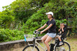 © leungchopan - Woman riding bicycle with young child in seat
