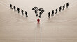 © Arpana - A red figure stands at a forked path beneath drawn question marks while black figures walk away on diverging routes, illustrating a career crossroads.