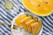 © ADDICTIVE STOCK - Yellow watermelon slices with lime water on striped cloth