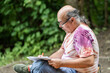 © ADDICTIVE STOCK - Mature man journaling outdoors for wellness and healthy aging