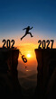 © Nacer - A silhouetted figure leaps across a chasm between the years 2026 and 2027 at sunset symbolizing new beginnings.