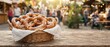 © W.O.W - Basket of salted pretzels on a rustic wooden table at an outdoor market. Traditional baked snack and street food concept with blurred people, cafe lights, and copy space.