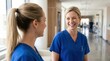 © Nats - Happy healthcare workers in blue scrubs sharing a positive moment in a medical clinic.