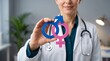 © Stock iT - Female doctor holding blue and pink gender symbols for reproductive health awareness in medical office professional concept