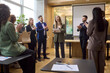© Studio Romantic - Speaker leads team training during office meeting. Colleagues applaud the leader and manager as the audience celebrates in a modern office. Concept of business recognition and leadership.