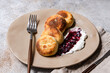 © RooM The Agency - Close-up of  a plate of sweet Syrniki pancakes with sour cream and blueberry jam  on a concrete table