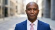 © PhanDesigns - A confident black businessman wearing a blue suit in a city setting.