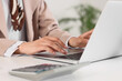 © Pixel-Shot - Business productivity and remote work, womans hands typing on laptop keyboard with calculator on office desk