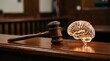 © Salehur - Wooden judge's gavel resting on polished courtroom bench beside a glowing translucent brain icon representing legal neuroscience and judicial decision making