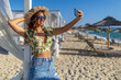 © Jelena - Young woman taking beach selfie during summer vacation