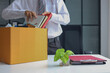 © Supitnan - Business professional packing up belongings after getting laid off.