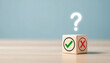 © Sundari - Wooden cube with tick mark and cross mark representing a yes or no choice