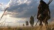 © Bhavesh - Prehistoric hunter gatherers carrying spears while walking through tall grass under dramatic cloudy sky, ancient human migration scene illustrating survival, early civilization and Stone Age life