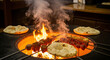 © Feri - Meat kebabs and fresh flatbread grilling over an open fire pit