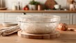 © Honey - Covered glass bowl with dough resting on a wooden board, a culinary concept showcasing homemade bread and baking ingredients on a kitchen countertop