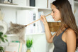 © PheelingsMedia - Woman at home cleaning furniture with duster